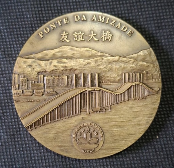 Medalha da ponte da amizade, assinada por Jorge Coelho - Medalha de Bronze - Na galeria central em relevo retratando a ponte e a cidade ao fundo na borda superior a inscrição em alto relevo Ponte Nobr