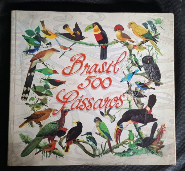 Álbum "Brasil 500 Pássaros" - com 245p - - Capa: Ilustrações coloridas de aves brasileiras: tucano, arara, sabiá, coruja, beija-flor. Arte estilo gravura naturalista- Estado: Capa desgastada, bordas a