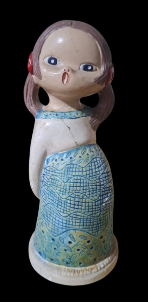 Menina "Mafalda style" - estuque - Alt. 15,5cm - Escultura decorativa anos 70-90. Menina de cabeça grande, tranças, vestido azul estampado e boca aberta surpresa. Estilo ingênuo/naif BR. - Forma: Cabe
