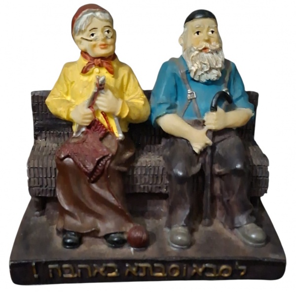 Escultura "Saba e Savta" - Casal de Idosos no Banco - Medidas: 10,5cm x 6cm x 9,5cm - - Material: Resina ou gesso pintado. Peso médio- Cena: Vovô e vovó sentados no banco. Vovó de amarelo tricotando.