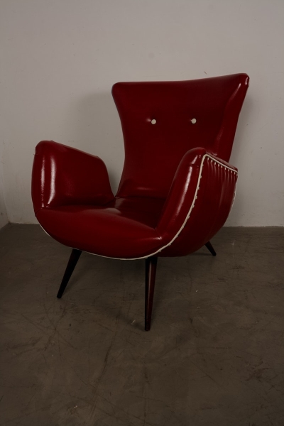 Joias . Poltrona em couro vermelho com estrutura em madeira escura. Acabamento com ...