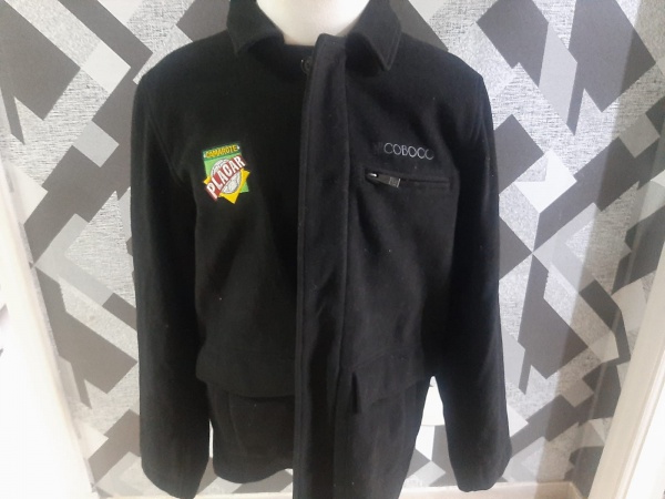 Joias . Jaqueta preta de estilo sarja com fechamento por zíper e um patch bordado no ...