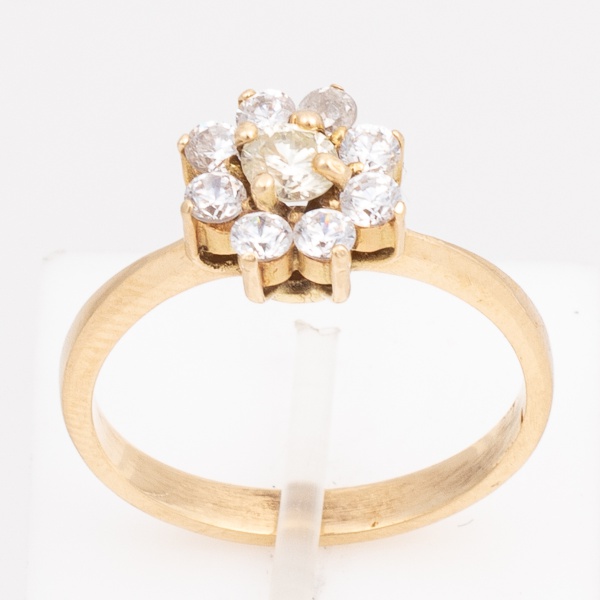 Anel "flor" em ouro amarelo, 18 K, cravejado com oito brilhantes de aproximadamente 6 pontos cada e um de aproximadamente 20 pontos. Aro 17. Peso 3,4 gr. (Por medida de segurança esse lote não se enco