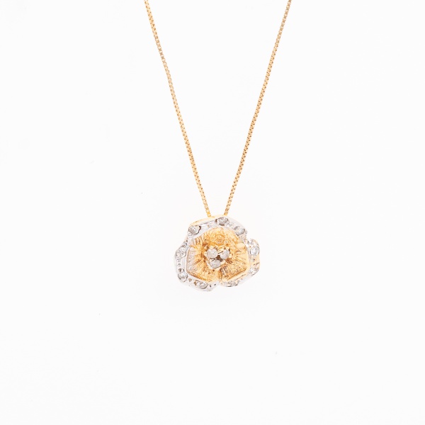 Cordão com pingente "flor" em ouro branco e amarelo, contrastado 750 K, cravejado com doze diamantes. Med. aberto 45 cm. Peso 2,2 gr. (Por medida de segurança esse lote não se encontra em nossa loja).
