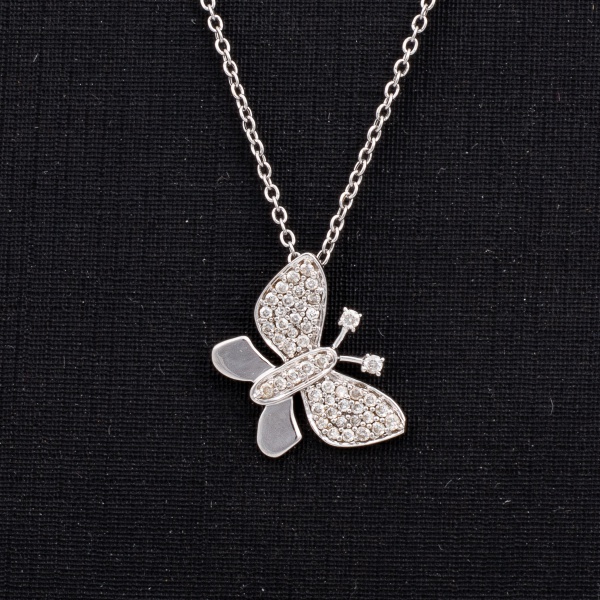Cordão com pingente "borboleta" em ouro branco, contrastado 750 K. Pingente cravejado de diamantes. Med. aberto 47 cm. Peso 2 gr. (Por medida de segurança esse lote não se encontra em nossa loja).