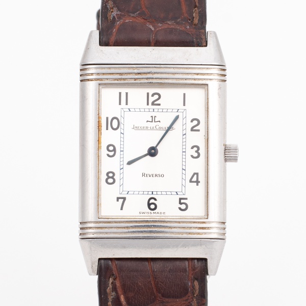 JAEGER LE COUTRE - REVERSO - Relógio suíço de pulso. Caixa em aço (med. 3,9 x 2,2 cm). Excelente estado. Visor acrílico, mostrador prateado com algarísmos arábicos. Pulseira em couro marron e fivela o