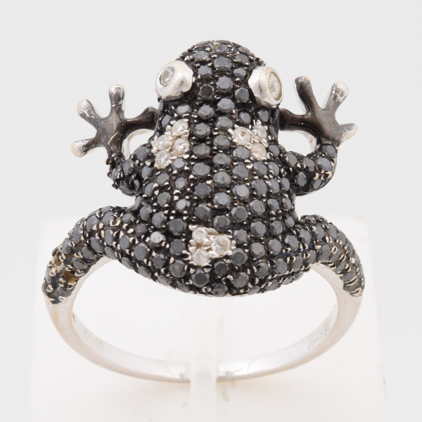 Anel em ouro branco, 18 k. Fino trabalho em forma de sapo, cravejado de 0,96 pontos de diamantes negros e brancos. Aro 16. Peso 5,5 gr. (Por medida de segurança esse lote não se encontra em nossa loja