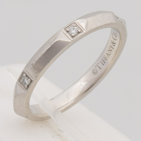 TIFFANY CO - Aliança em platina, contrastada, com seis brilhantes. Aro 17. Peso 5 gr. (Por medida de segurança esse lote não se encontra em nossa loja).