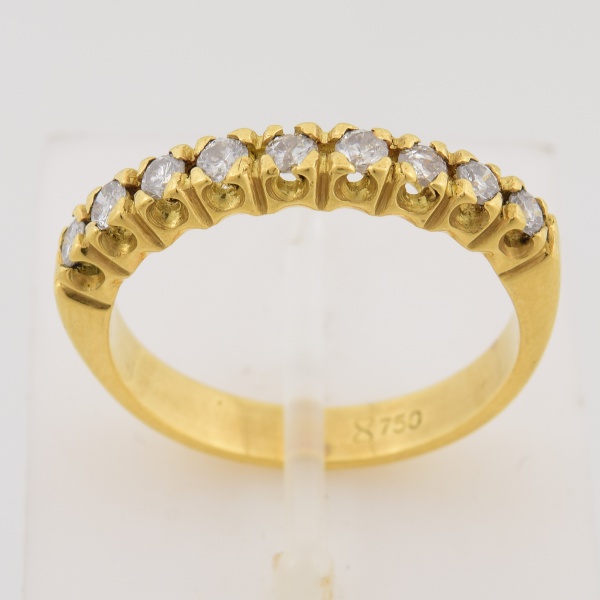 Meia aliança em ouro amarelo 18k, contrastado 750k, cravejado com nove brilhantes de aproximadamente 3 pts cada. Peso 3,3 gr., (Por medida de segurança esse lote não se encontra em nossa loja).