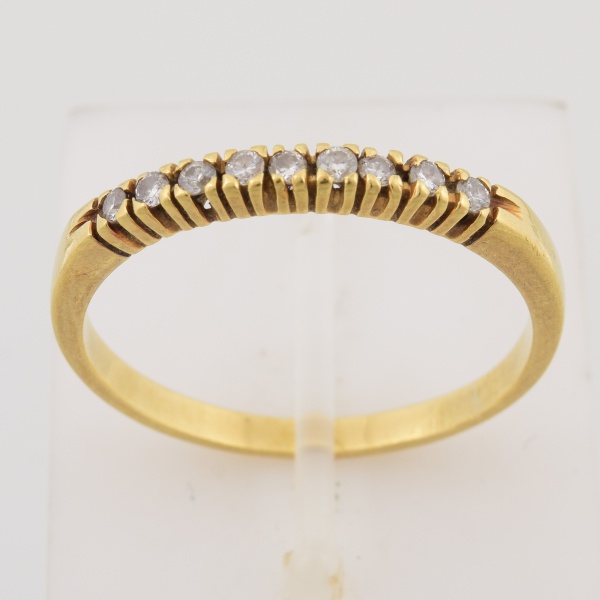 Meia aliança em ouro amarelo 18k, cravejado com nove brilhantes de aproximadamente 1 pt cada. Aro 20. Peso 2,3 gr. (Por medida de segurança esse lote não se encontra em nossa loja).