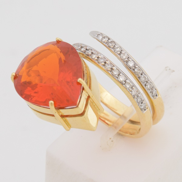 Anel em ouro amarelo, 18 k com opala de fogo central lapidação gota e aro cravejado de diamantes. Aro 18. Peso 10,2 gr. (Por medida de segurança esse lote não se encontra em nossa loja).