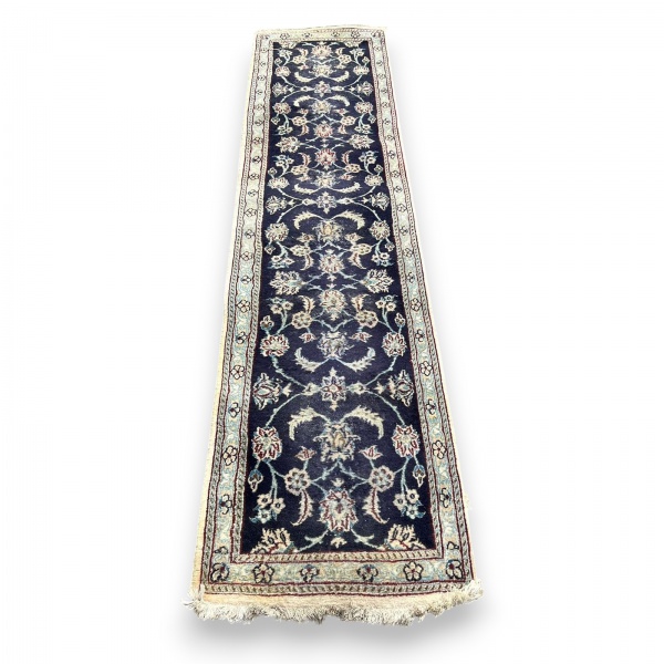 Tapete estilo passadeira com padronagem floral em tons de azul-marinho, bege, vinho e azul-claro, com franjas nas extremidades; medidas 2,91 x 0,66 m; necessitando de limpeza, com marcas do tempo e us