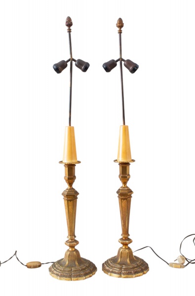 Par de luminárias de mesa em metal dourado com haste articulada e cúpulas direcionáveis, bases ricamente ornamentadas e detalhes decorativos no topo. Peças com fiação aparente, interruptores originais