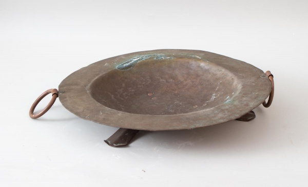 Fruteira ou centro de mesa em metal martelado com alças laterais circulares e base elevada tripé. Peça com pátina escurecida, oxidação, marcas do tempo e desgastes conforme fotos. Medida 41 cm de diâm