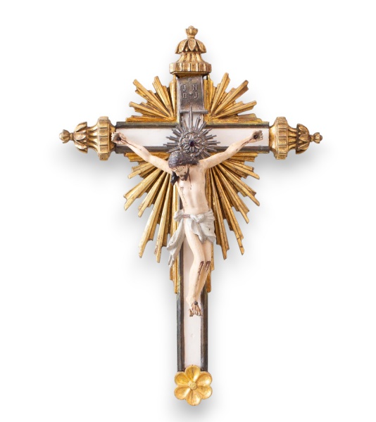 Crucifixo de parede em madeira com detalhes em prata e douração, apresentando imagem de Cristo crucificado em relevo, resplendor ao fundo e inscrições J N R J na parte superior, medindo 60 cm de compr