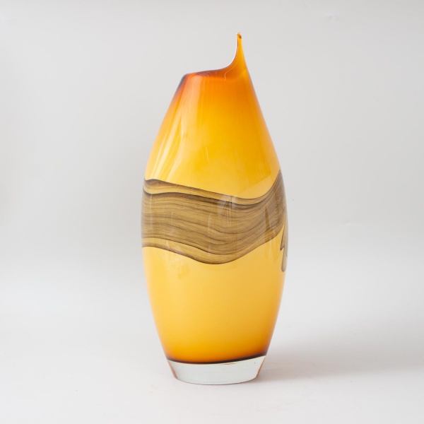 Vaso em vidro soprado Murano, corpo ovoide de grande porte em tom âmbar/mel com gradação para castanho escuro na boca assimétrica e recortada. Apresenta faixa central decorativa em vidro mesclado com