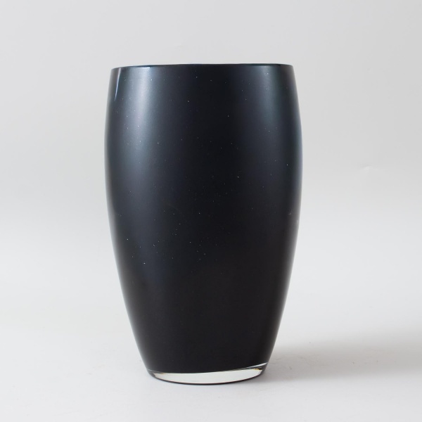 Vaso de design contemporâneo em vidro soprado preto, corpo ovoide com boca larga e acabamento polido de alta reflexividade. Superfície lisa e uniforme em preto intenso, com interior aveludado. Linhas 