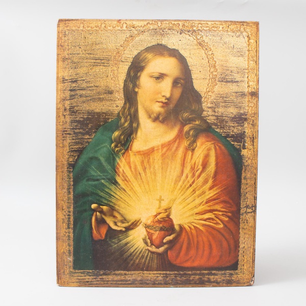 Ícone do Sagrado Coração de Jesus, impressão cromolitográfica sobre madeira com fundo dourado envelhecido e bordas decorativas em relevo dourado. Representa Cristo segurando o coração irradiante com c