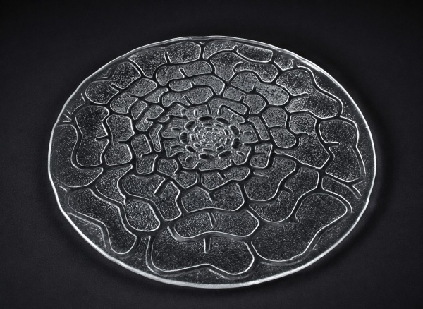 Prato para bolo em vidro translúcido com decoração em relevo formando desenho floral espiralado; peça de design moderno e acabamento texturizado; medindo 40 x 40 cm; apresenta sinais de uso e marcas d