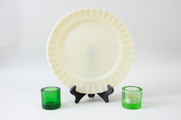 Lote contendo prato em vidro opalino na tonalidade verde-clara com borda ondulada e 2 suportes para velas em vidro verde; prato medindo 30 cm de diâmetro; apresentam sinais de uso, marcas do tempo e d