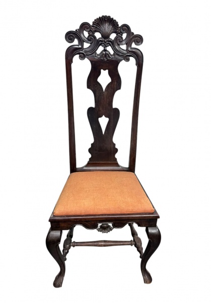 Cadeira de estilo clássico em madeira escurecida, com espaldar alto ricamente entalhado com motivos concheados e volutas, assento estofado em tecido na cor terracota e pernas curvas; medidas 130 cm de
