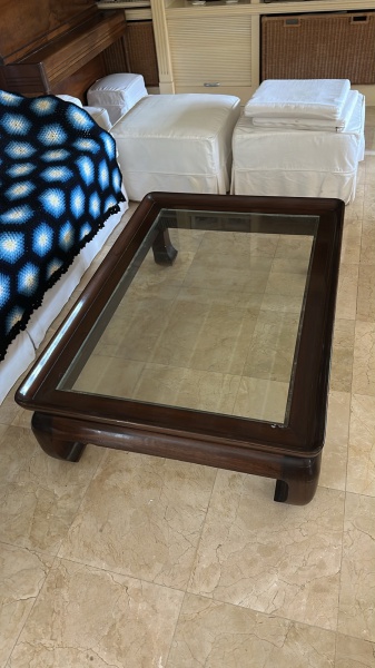Mesa de centro retangular em madeira, com tampo em vidro encaixado e pés curvos robustos, medindo 36 x 130 x 90 cm (altura x comprimento x largura); apresenta sinais de uso, pequenos riscos, desgastes