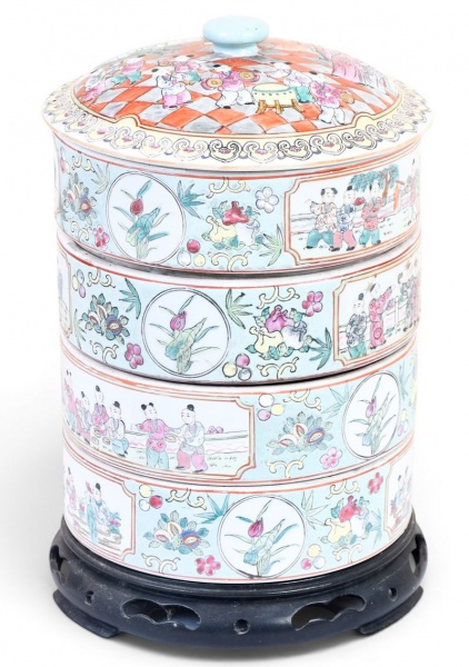 Potiche chinesa em porcelana policromada com decoração oriental figurativa e floral, composta por quatro compartimentos empilháveis com tampa, apoiada sobre base de madeira entalhada, medindo 31 cm de