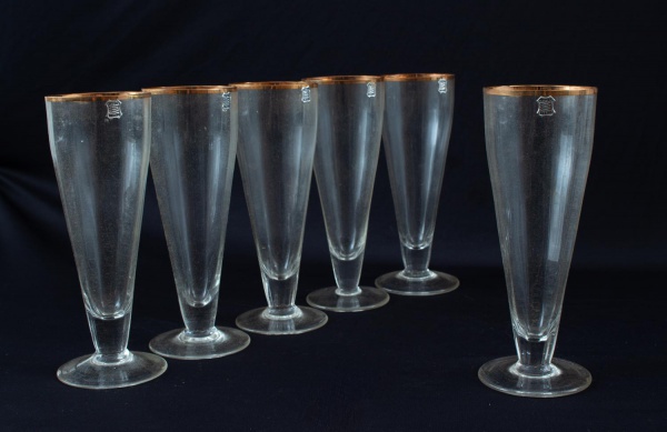 Lote contendo 6 taças em cristal Hering com borda dourada, corpo facetado e base circular. Peças com marcas do tempo, desgastes no dourado e sinais de uso conforme fotos. Altura aproximada: 20 cm.