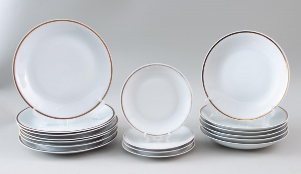Lote contendo 7 pratos rasos, 6 pratos fundos e 4 pratos de sobremesa da manufatura Porcelana Renner, Porto Alegre, em porcelana branca com friso dourado; apresenta marcas do tempo, desgastes e sinais