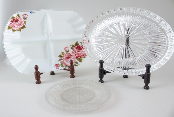 Lote contendo petisqueira em porcelana decorada com flores, prato para bolo em vidro prensado incolor e prato em vidro fosco decorado. Peças com marcas do tempo e uso, conforme fotos.