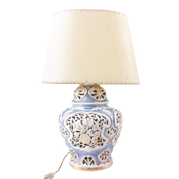 Abajur em porcelana vazada decorada em tons de azul e branco, com cúpula revestida em tecido. Peça com marcas do tempo, desgastes e sinais de uso. Altura 53 cm. Funcionamento não testado. Conforme fot