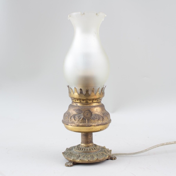 Abajur estilo lampião em metal dourado trabalhado, com cúpula em vidro fosco e instalação elétrica adaptada; medindo 32 cm de altura; apresenta marcas do tempo, oxidação, desgastes no acabamento e sin