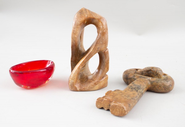 Lote contendo 3 peças decorativas diversas, sendo escultura abstrata em pedra, chave decorativa e pequeno recipiente em vidro vermelho. Apresentam sinais de uso, marcas do tempo e desgastes.