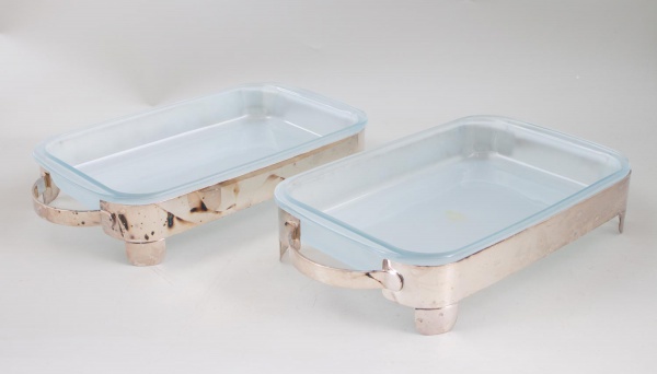 Suporte para refratário em inox Riva - sem tampa, medindo 35 x 21 cm; apresentam sinais de uso, marcas do tempo e oxidação nos suportes metálicos.