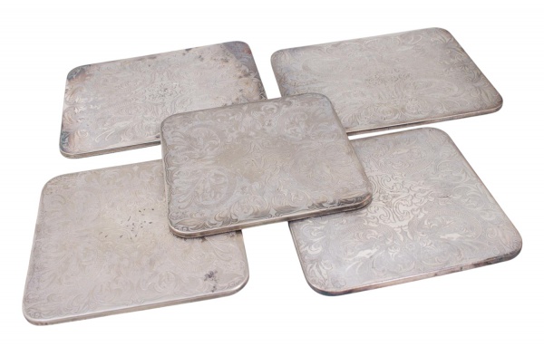Lote com 5 descansos de panela/apoios de mesa Pendragon, Silver Plated England, em metal prateado com decoração em relevo; tamanhos variados; apresentam sinais de uso, marcas do tempo, riscos superfic