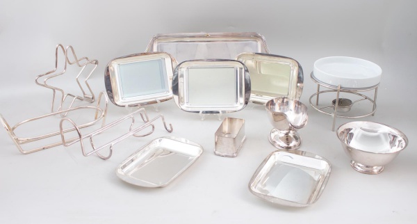 Lote contendo peças para servir e mesa em metal prateado e porcelana, composto por bandejas, molheiras, suportes, porta-guardanapos, travessas e demais acessórios variados; apresentam sinais de uso, m