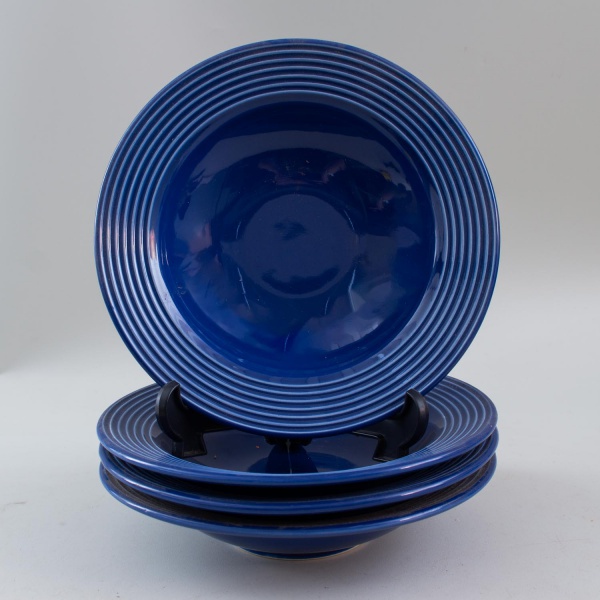 Lote com 4 pratos fundos da coleção La Tavola, Porto Brasil, em cerâmica esmaltada azul, medindo 21 cm de diâmetro; apresentam marcas de uso e sinais do tempo.