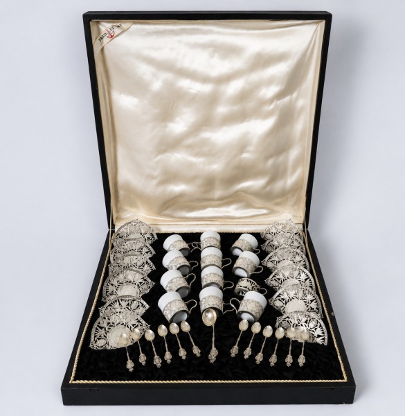 Conjunto para café em prata de lei 900, acondicionado em estojo original revestido internamente, composto por 11 xícaras em porcelana com suportes ornamentados em prata, 12 pires rendados em prata e 1