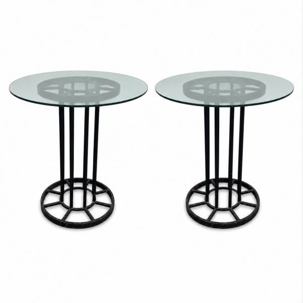 Par de mesas laterais com tampo circular em vidro translúcido e estrutura em metal pintado na cor preta, apresentando base vazada com desenho geométrico. Medem 50 cm de altura e 53 cm de diâmetro cada