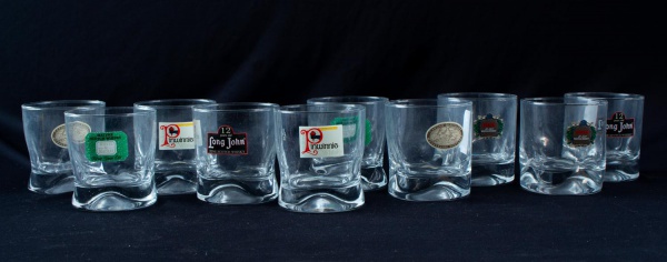 Lote contendo 10 copos baixos para whisky em vidro incolor, decorados com logotipos de marcas de whisky, altura: 9 cm. Apresentam sinais de uso e marcas do tempo.