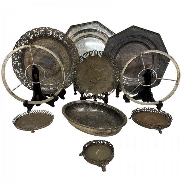 Lote com 10 peças em metal prateado, composto por bandejas, travessas, pratos decorativos e pequenos porta-objetos de formatos variados, incluindo modelos vazados e ornamentados. Diversos tamanhos. Ap