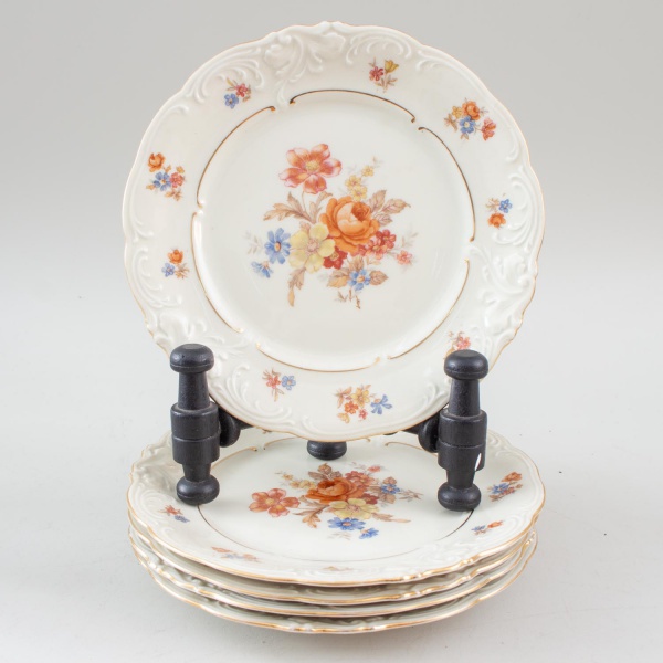 Conjunto com 5 pratos decorativos em porcelana KPM Poland, com decoração floral policromada e bordas em relevo com filetes dourados; medindo aproximadamente 19 cm de diâmetro cada. Apresentam sinais d