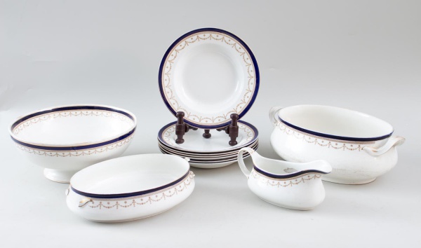 Conjunto parcial em porcelana inglesa Bleu de Roi Alfred Meakin Ltd., composto por 7 pratos fundos, 1 molheira, 2 sopeiras sem tampa e 1 travessa redonda contém bicados ,decorados com filetes dourados