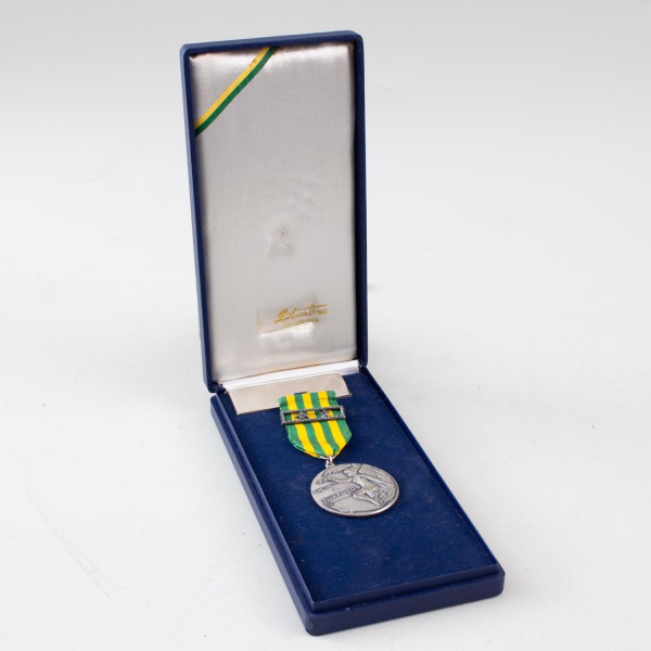 Medalha comemorativa da Missão de Paz no Líbano e Marrocos, acompanhada de estojo original; fita nas cores verde e amarela com passador metálico; medalha em metal com representação alegórica da paz e