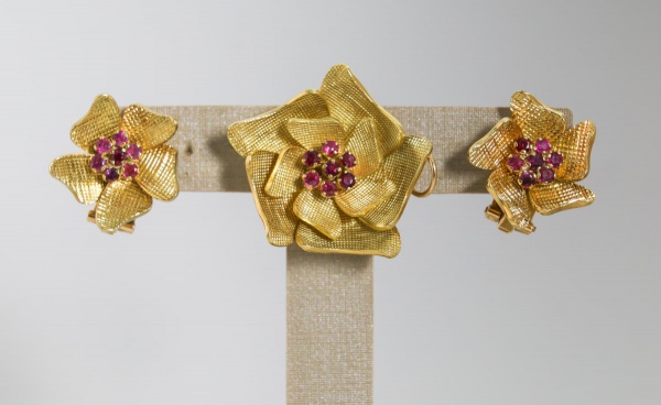 Conjunto em ouro amarelo 18K composto por broche e par de brincos de pressão, com design em forma de plumas estilizadas e acabamento texturizado, pesando ao todo 56,5 g;