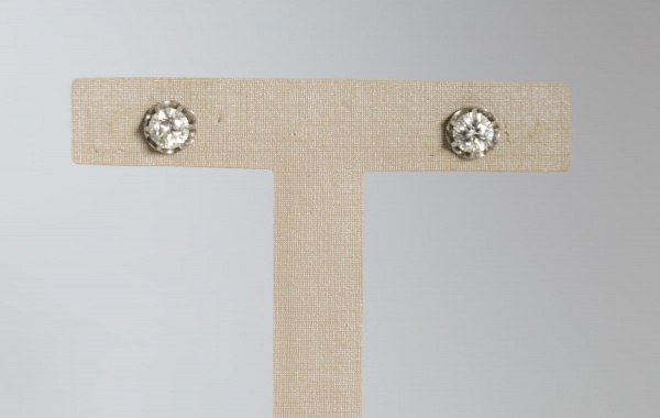Par de brincos em platina, pesando 2,9 g, com diamantes lapidados em engaste solitário de formato circular, apresentando elegante estrutura vazada; peças clássicas de uso feminino