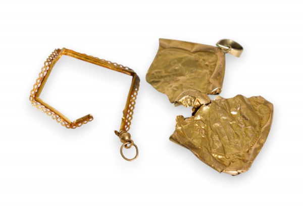 Lote contendo fragmentos e partes de joias em ouro 18k, pesando em conjunto 2,7 g, composto por elementos avulsos e danificados de pingentes e armações ornamentais, vendidos no estado em que se encont