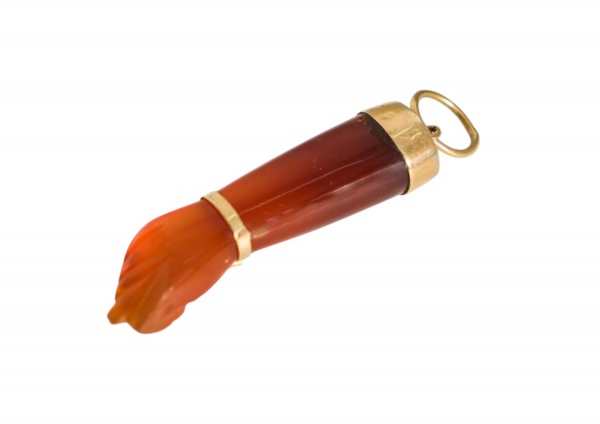 Pingente em ouro 18k com terminal em formato de figa esculpida em cornalina de tonalidade avermelhada, pesando 5 g, peça de caráter amuletário e decorativo,