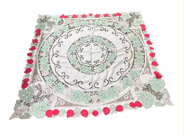 Toalha de mesa em linho com rico trabalho em renda Richelieu e aplicações policromadas de motivos florais e frutais, medindo 161 x 163 cm; apresenta pequenas manchas, sinais de uso, marcas do tempo e