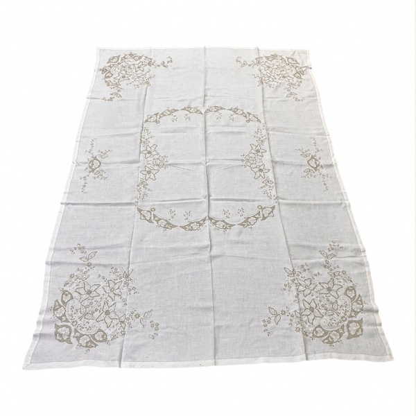 Toalha de mesa com bordados em motivos florais distribuídos pelos cantos e centro, medindo 201 x 142 cm; apresenta discretas manchas, vincos de armazenamento, sinais de uso e marcas do tempo.